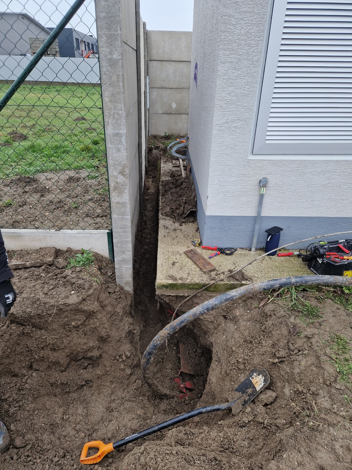Výkop ryhy pre uloženie zemného elektrického kábla popri objekte